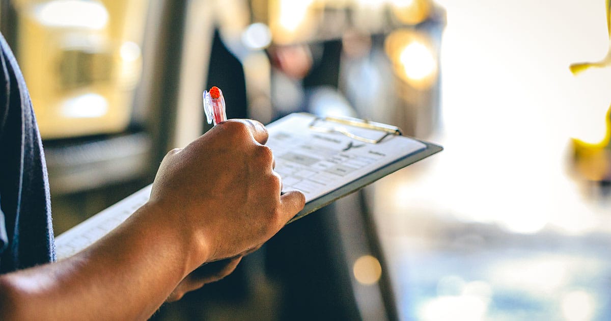 Man signing document on clipboard