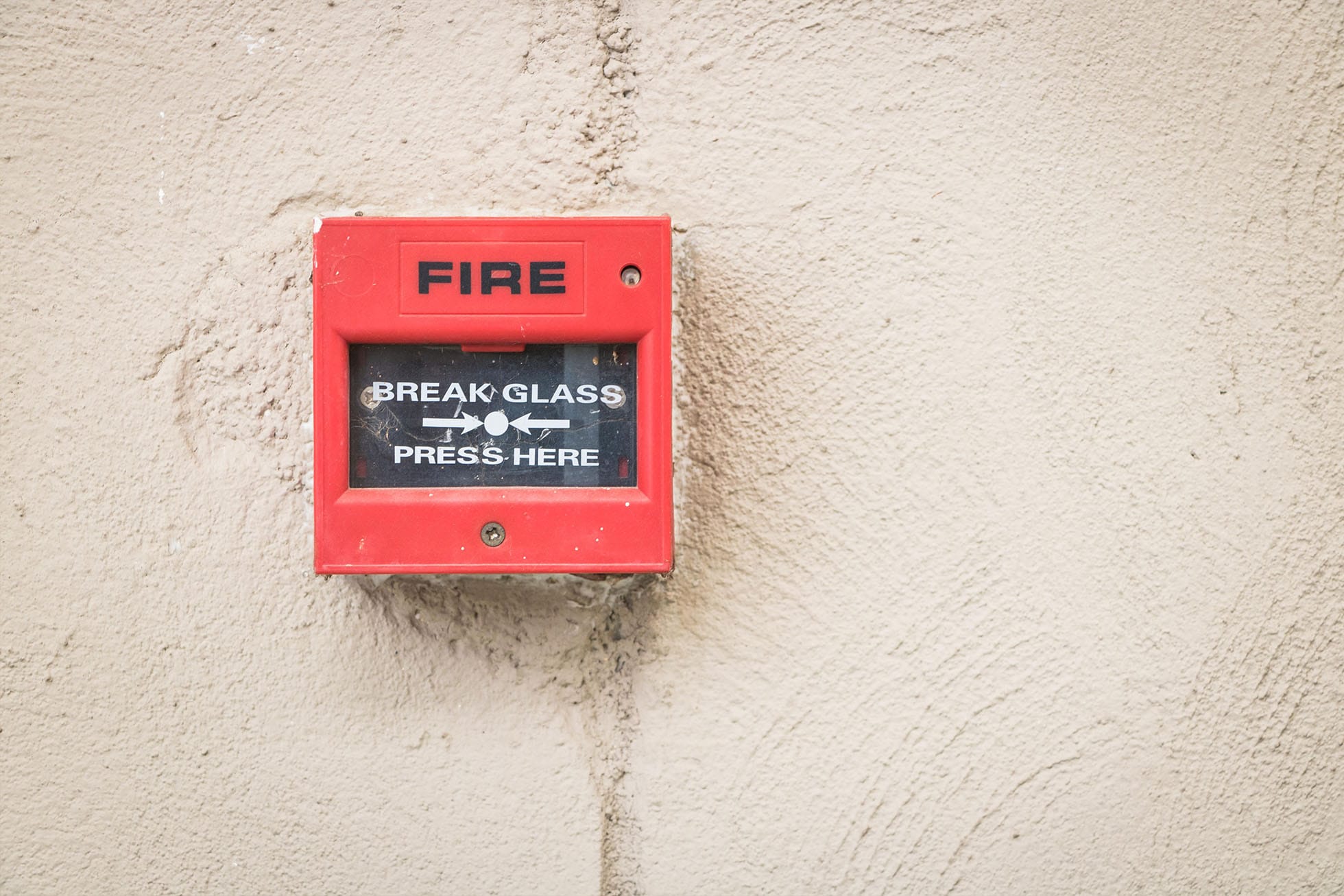 Manual call point on textured white wall