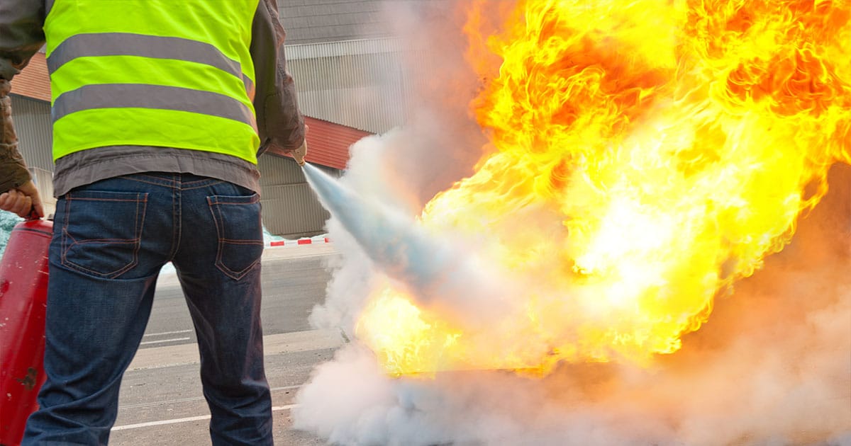 Man with high vis jacket extinguishing fire