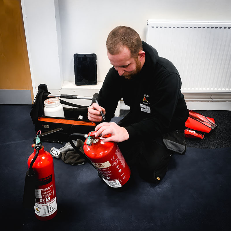 Engineer servicing fire extinguisher