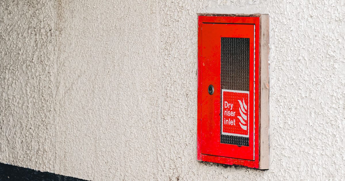 Dry riser inlet cabinet on textured wall