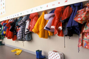 Primary school coat hanger with kids coats hanging from it