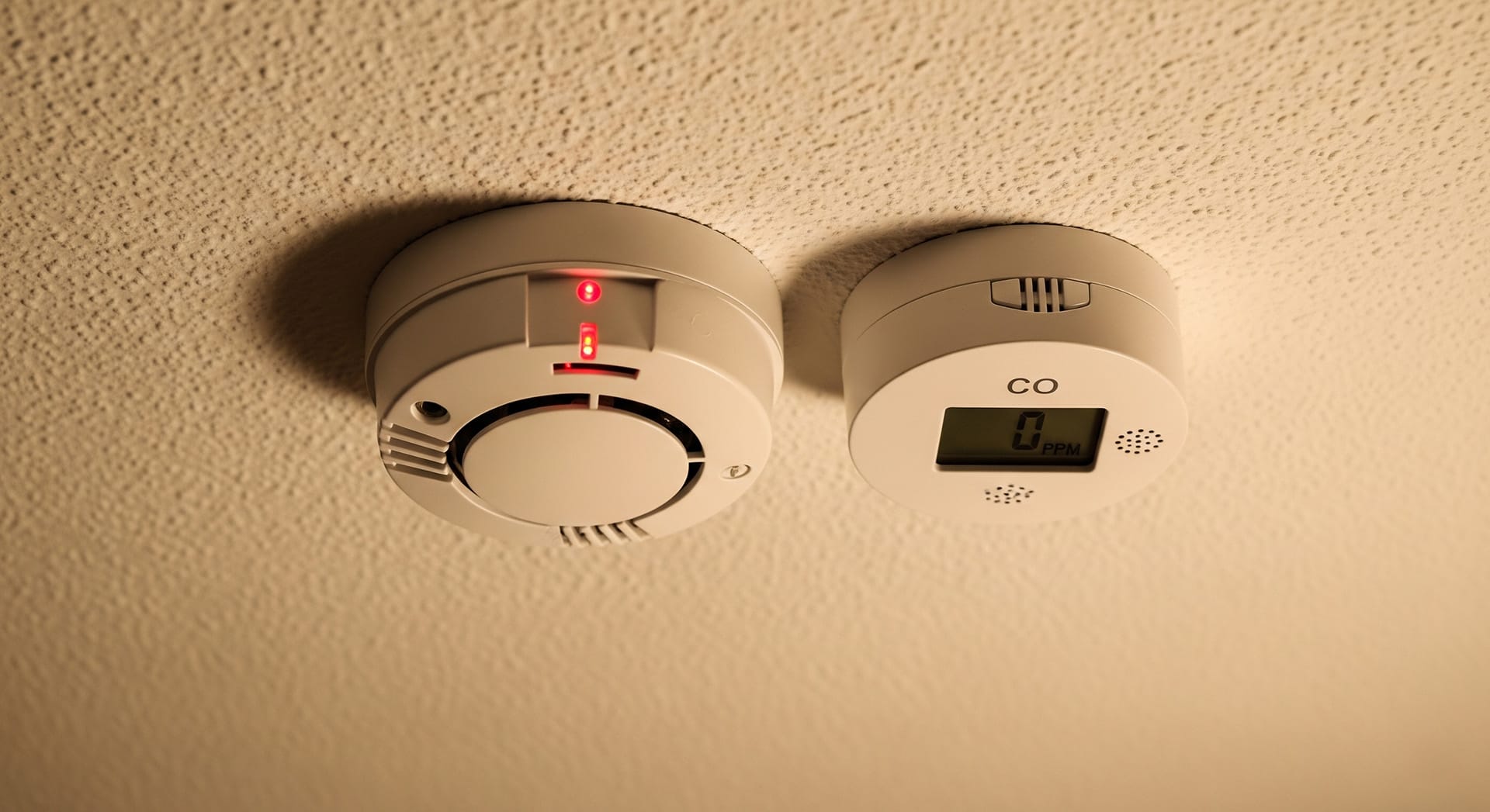 An image of a fire alarm and a carbon minoxide alarm fixed to a ceiling