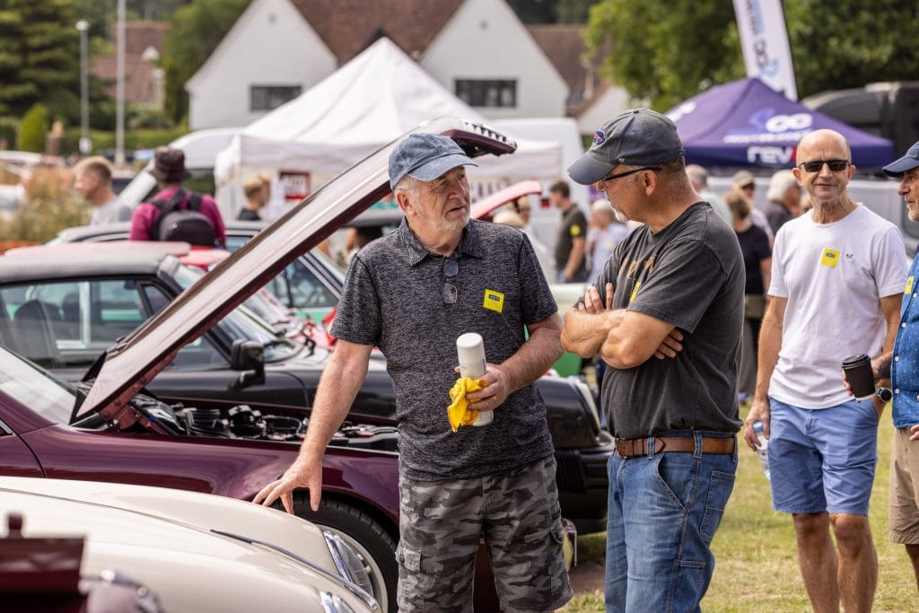 Two men chatting in from on a classic Porche at Classics On The Common